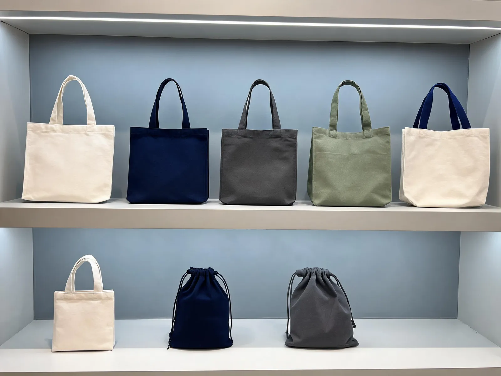 Muestras de bolsas tote y con cordon en una sala de exposicion de exportacion